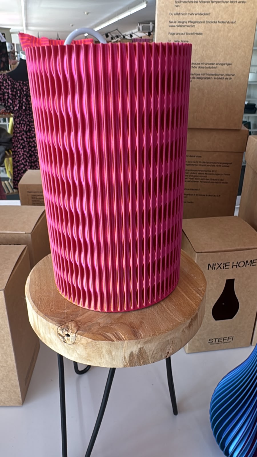 Pinke Vase Meilli mit Rillenstruktur und dezenten Herzdetails auf einem Hocker.