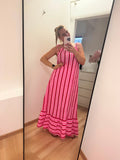 Kleid mit horizontalen Streifen ca. 3-4 cm Dick in pink, rosa und rot abwechselnd.
Der Saum ist dann vertikal in gleicher Farbe gestreift. Spaghettiträger mit knoten